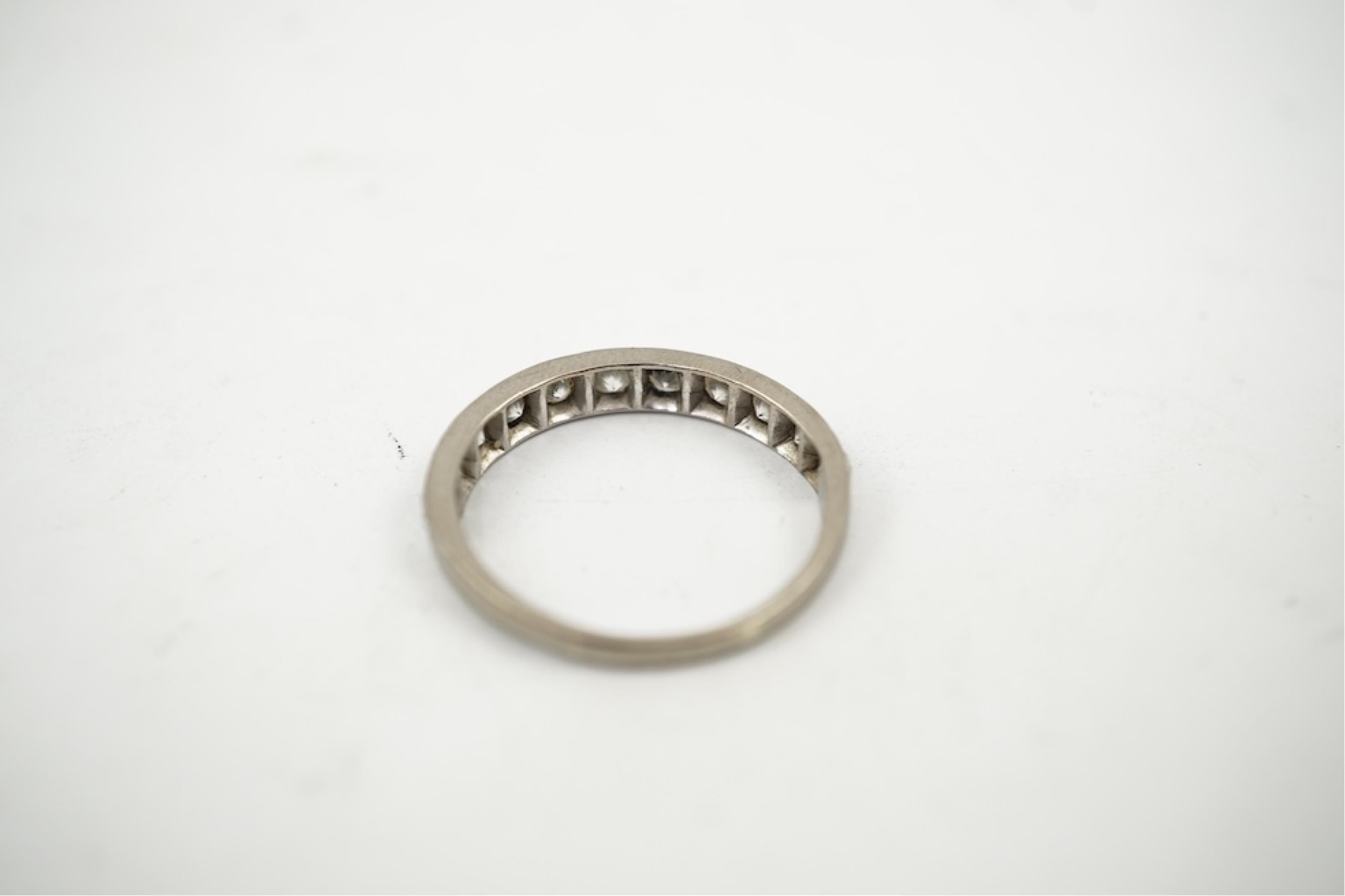 An 18ct white metal and graduated eleven stone diamond set half eternity ring, size P/Q. gross weight 3 grams.